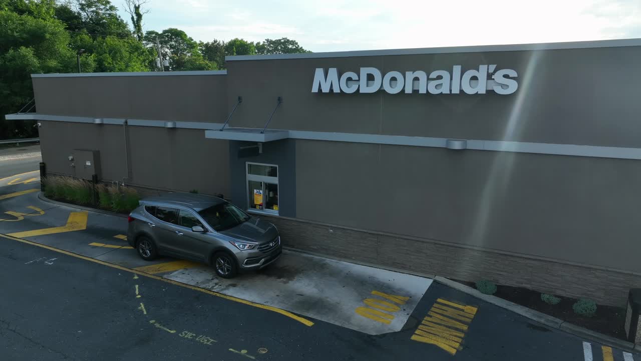 McDonald's restaurant drive-thru. Aerial shot of vehicle at fast food window. American food theme.