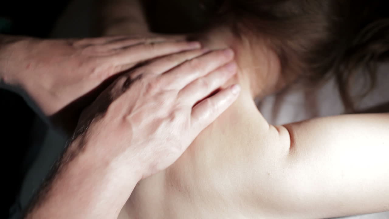 젊은 여성이 등 마사지를 받고 있습니다.