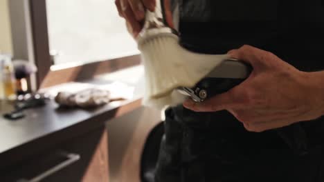 Close-up-view-hairdresser-cleaning-the-electric-razor