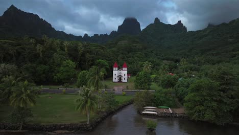 eglise de la sainte famille church of the holy family moorea mo'orea french polynesia drone aerial tahiti pacific island catholic historic building temple of papetoa dark cloudy moody forward pan up