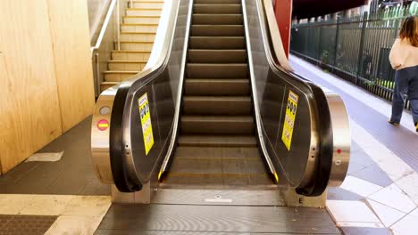 individuo corriendo más allá de la escalera mecánica en la estación de melbourne