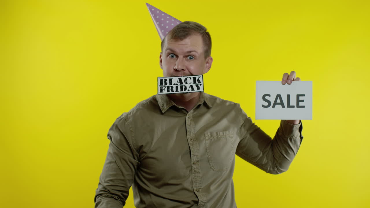매력적인 남자가 판매 단어와 블랙 프라이데이 텍스트 문구를 보여줍니다. 휴가 할인, 저렴한 가격