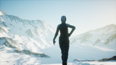 woman standing in snow wearing warm clothes in mountains