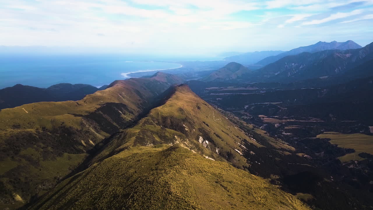 toma aérea revelada del hermoso brumoso mt alexander, rango de kaikoura hacia el mar