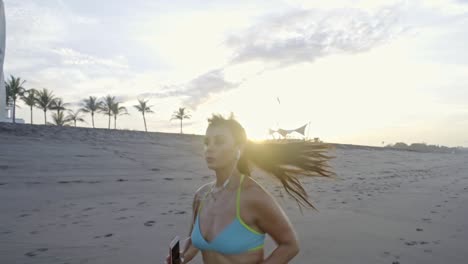 woman listening to music and running on beach