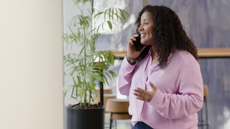 Casual-biracial-businesswoman-using-smartphone-in-office,-slow-motion-with-copy-space