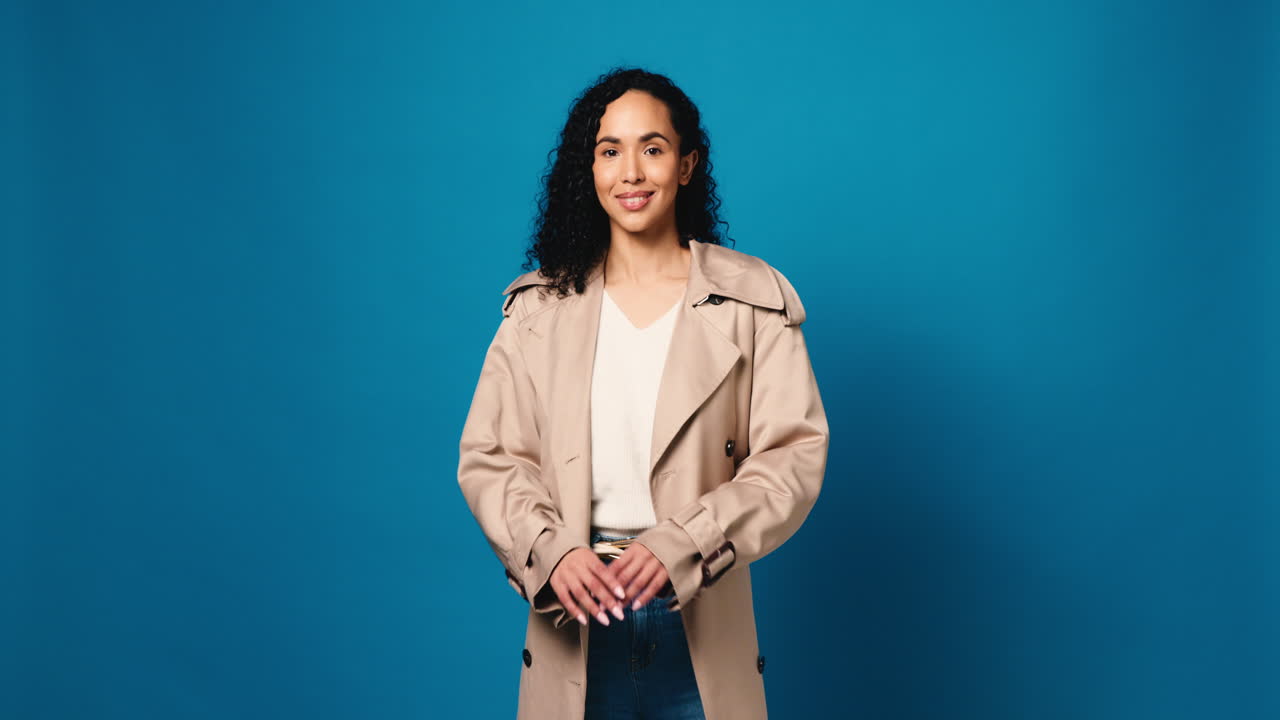 Woman in trench coat against blue background