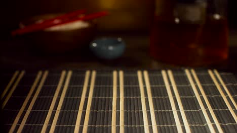 close up of a salmon sushi roll on a black plate.