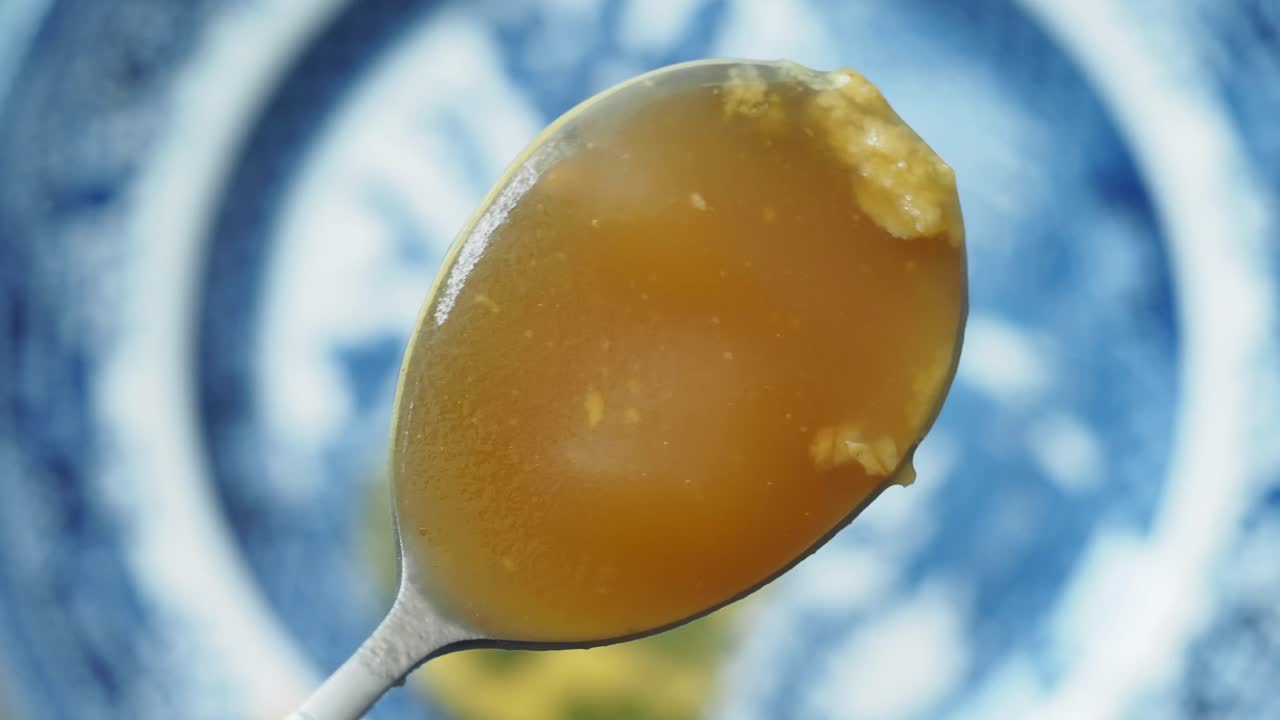 A close-up of a spoon holding a yellowish sauce
