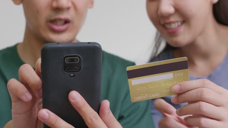 happy asian man and woman booking ticket online from retail store.