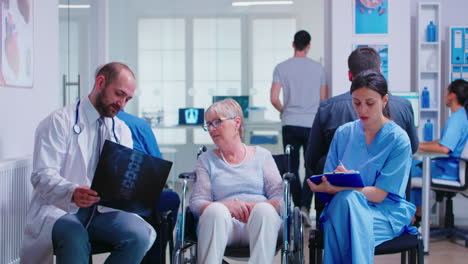 doctor holding radiography of disabled senior woman in wheelchair