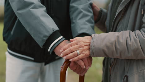 hands, cane and senior couple in nature