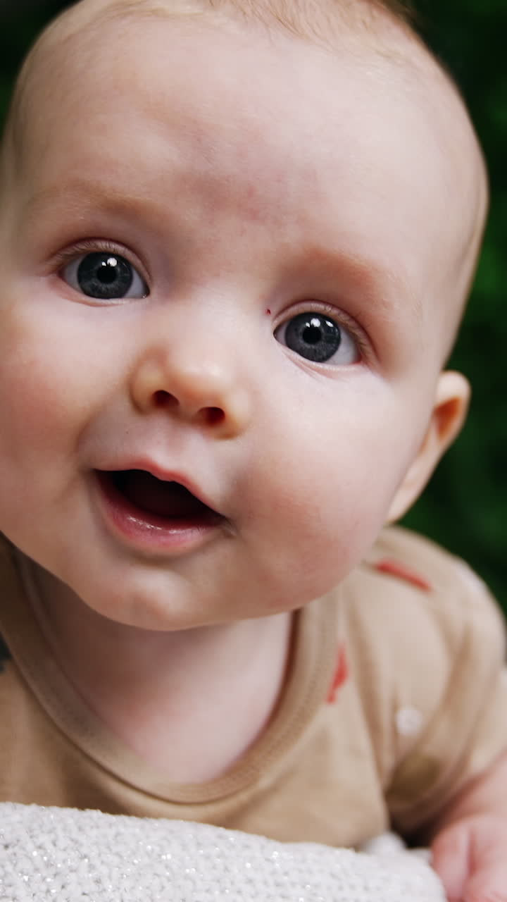Smiling baby portrait lifestyle. funny little newborn baby on nature lying. Vertical video