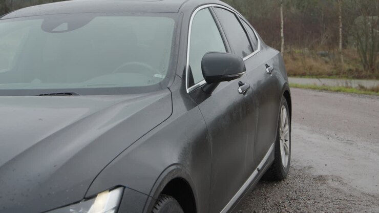 Berlina di lusso nera che viene aperta e sbloccata con la chiave dell'auto, panoramica.
