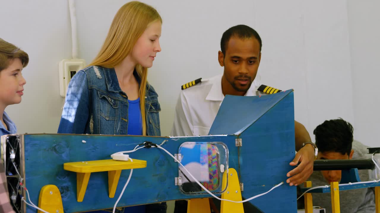 piloto masculino explicando sobre la máquina a los niños 4k