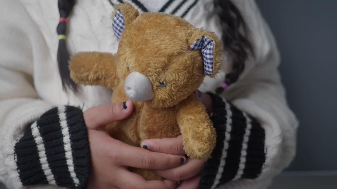 En pige, der holder en bamse