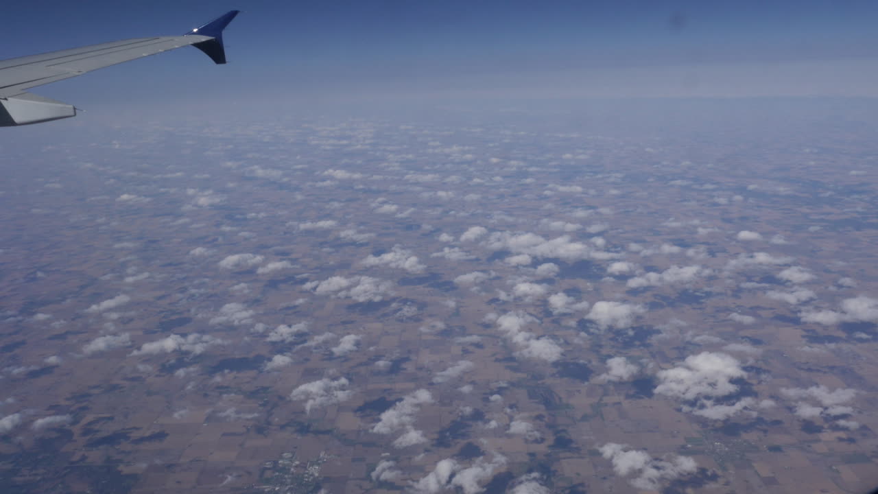 Stunning Aerial View of Farmland and Clouds from Airplane Window