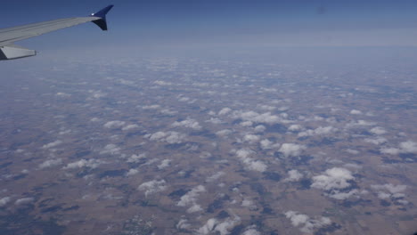 stunning aerial view of farmland and clouds from airplane window