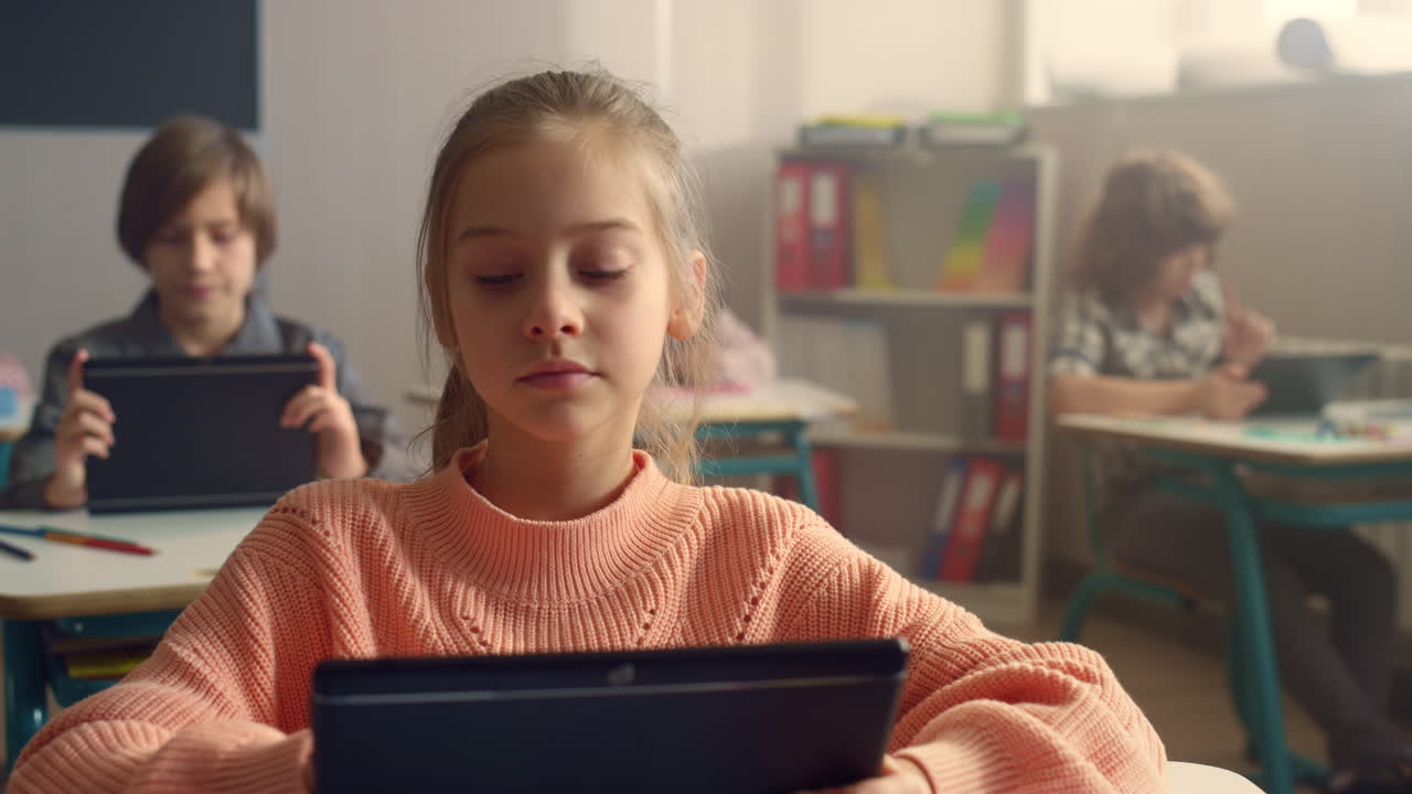 학교에서 수업 중에 디지털 태블릿에서 인터넷을 검색하는 학생