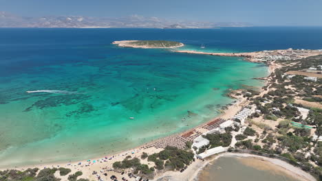 drone flying over the beach in paros with people swimming and relaxing