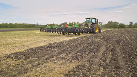 Farming-tractor-driving-aalong-agricultural-field.-Agricultural-equipment