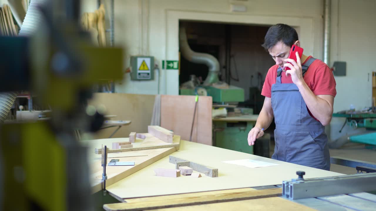 Man on a Phone Call Working in a Woodworking Workshop