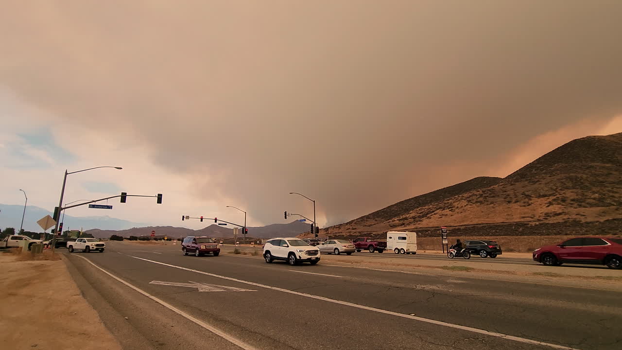 tráfico conduciendo en la carretera en la ciudad de hemet con cielo ahumado durante el incendio de fairview en el condado de riverside, california, estados unidos
