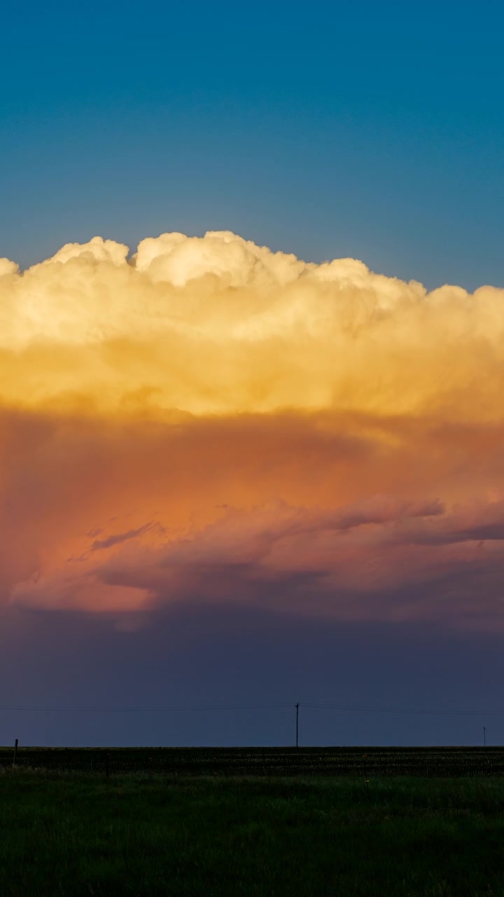 Fiery evening clouds sweeping through a warm and dramatic sunset sky