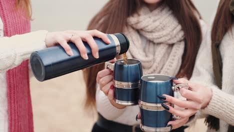 Chica-Está-Sirviendo-Té-En-Tazas-Metálicas-De-Sus-Amigas