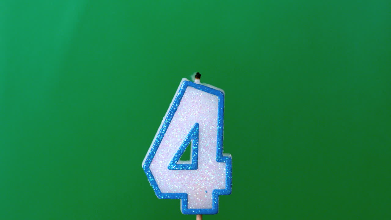 Four birthday candle flickering and extinguishing on green background