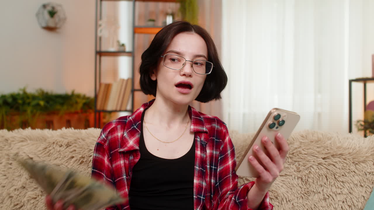 Happy woman celebrating money win on smartphone raising arms after hitting jackpot in online lottery