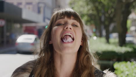 retrato de una hermosa mujer joven soplando chicle riendo alegremente disfrutando de diversión juguetona en una vibrante calle de la ciudad urbana por la mañana