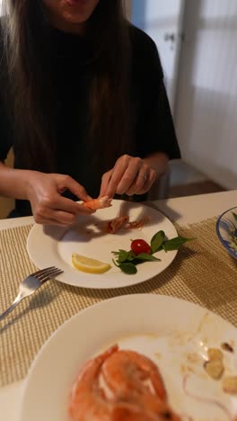 mujer comiendo una cena de camarones