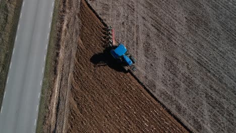 a zenith shot focused on a tractor plowing spinning slowly center in it