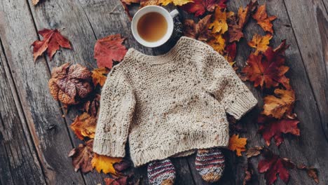 cozy autumn scene with sweater and hot drinks on rustic table