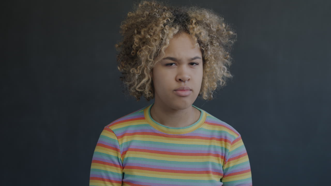 Portrait of a Young Woman with Curly Hair and Rainbow Striped Shirt
