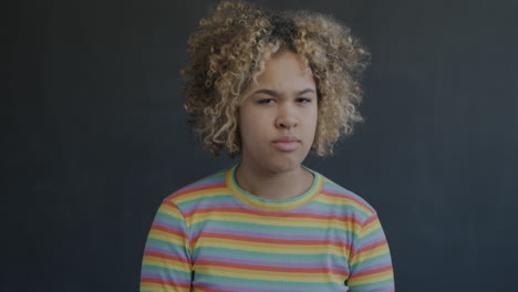 portrait of a young woman with curly hair and rainbow striped shirt