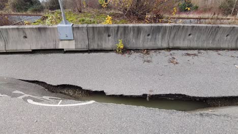 dolly shot flood aftermath on highway 11, cracked road, asphalt landslide, bc - canada