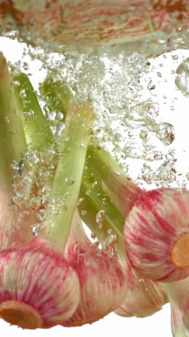 Bulbi d'aglio freschi immersi nell'acqua con bollicine