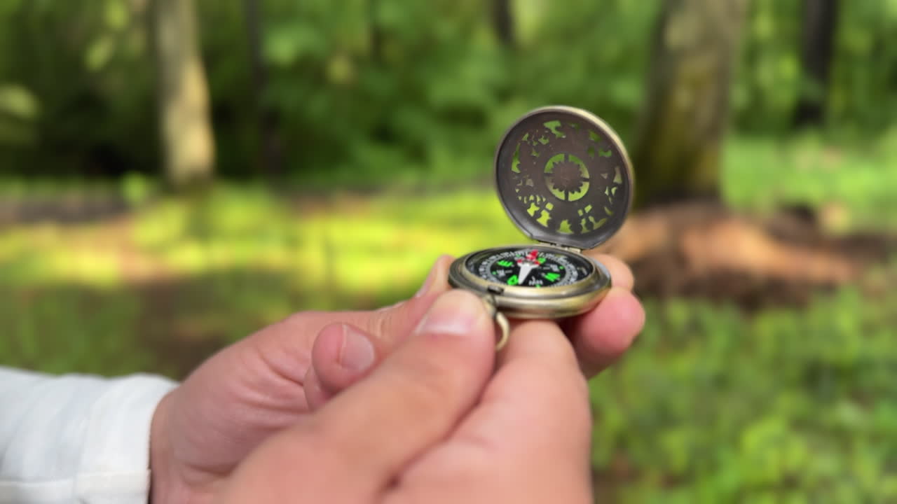 Hands holding an open compass in a Romanian forest