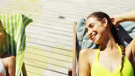 Animation-of-spots-over-happy-diverse-female-friends-lying-on-sunbeds