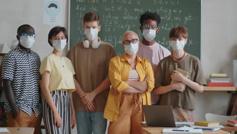 retrato de estudiantes multiétnicos y un maestro con máscaras protectoras