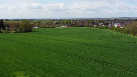 vista aérea descendente de un pueblo rural británico en el borde de los campos agrícolas, cheshire, inglaterra