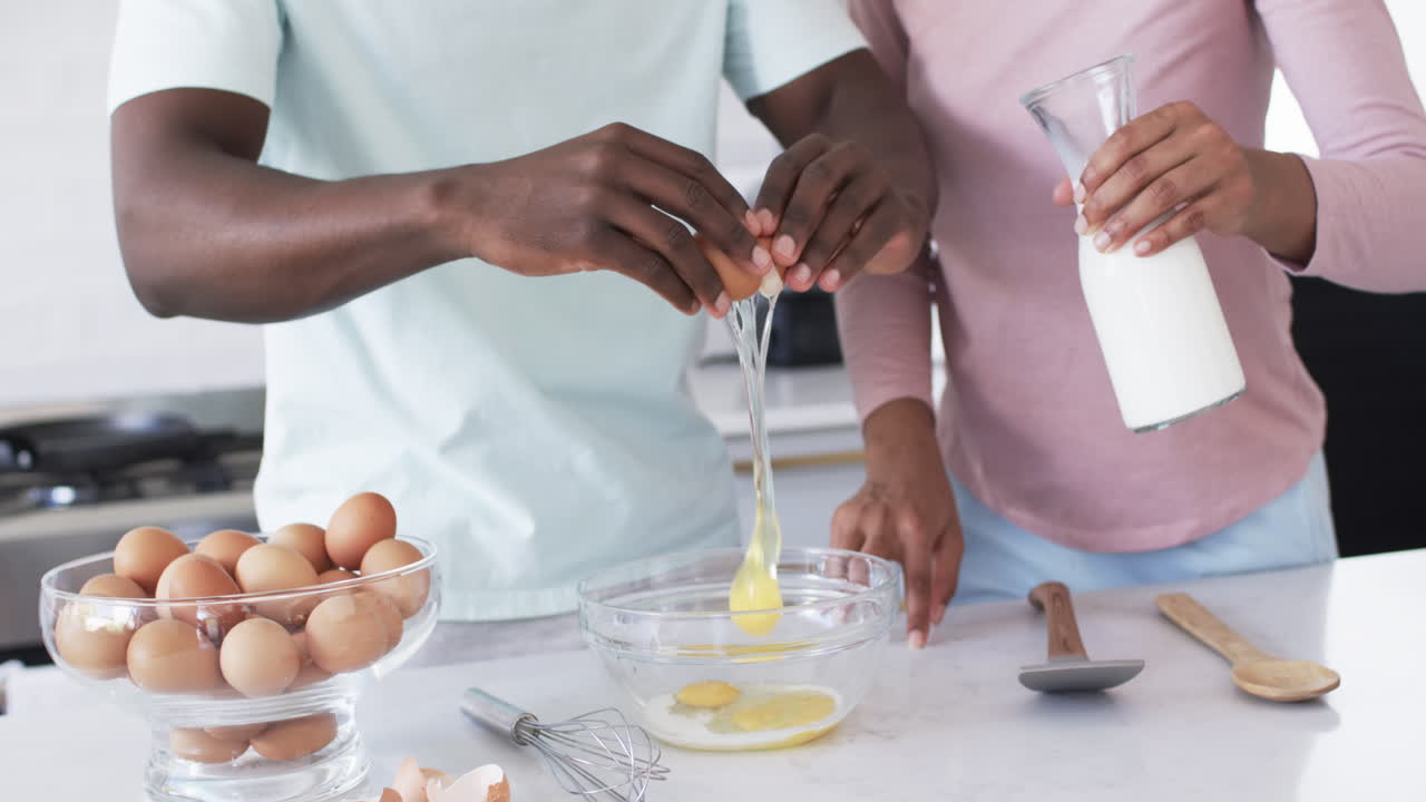 una pareja diversa está preparando el desayuno juntos en una cocina