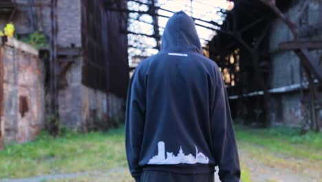 hombre caminando por una fábrica abandonada