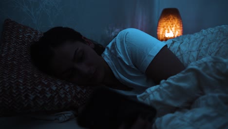 mujer usa teléfono inteligente en lugar de ir a dormir