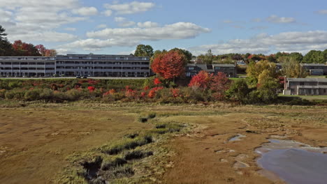 Wells-Maine-Aerial-v7-low-level-drone-flyover-salt-marsh-estuary-towards-residential-neighborhood-surrounded-by-beautiful-fall-tress-during-autumn-season-at-daytime---October-2020