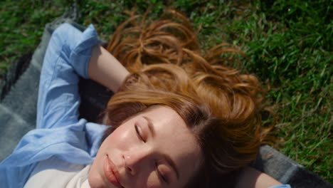 Closeup-happy-girl-lying-on-green-grass.-Beautiful-woman-enjoying-sun-outdoors.