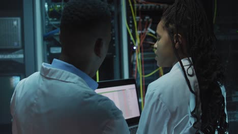 african american computer technicians using tablet working in business server room