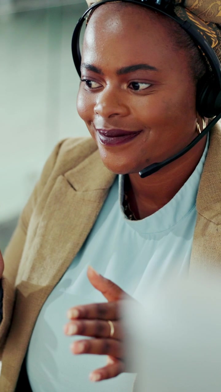 Professionel kvinde med headset under et videoopkald på kontoret